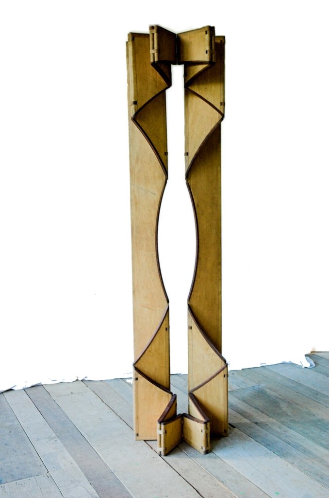 A escultura móvel Ó dobrada em uma coluna vertical estreita com pequena fenda oval central.