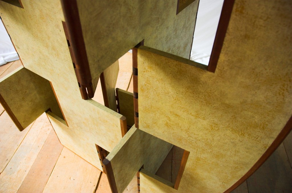 Vista superior aproximada dos encaixes geométricos e das dobradiças da escultura móvel Macho.