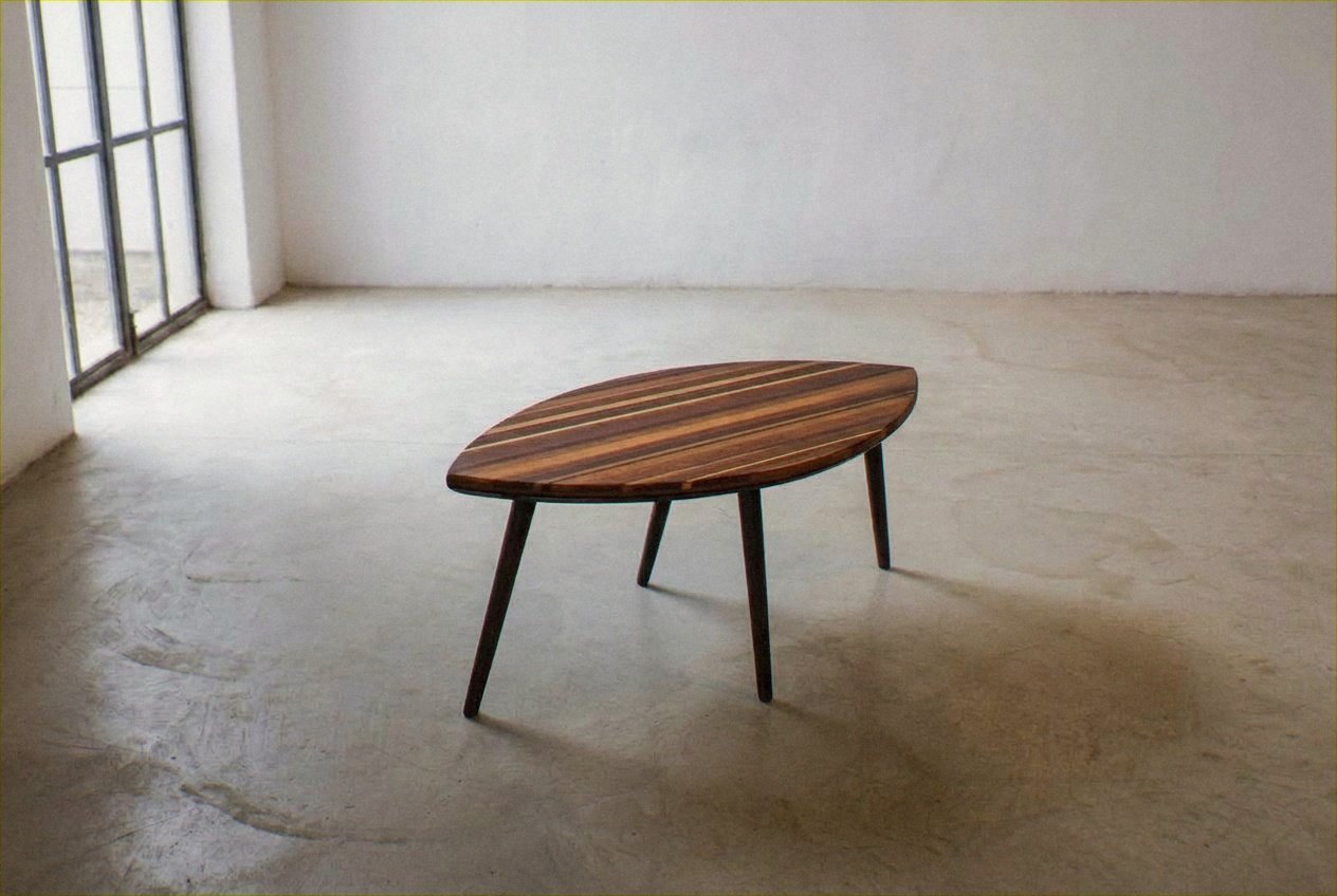 A mesa de centro Mesa Folha vista de cima sobre um piso claro diante de uma parede branca.