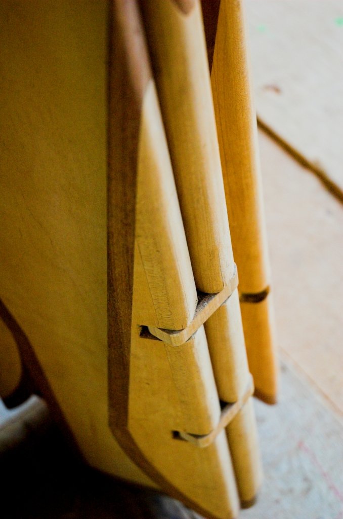 Detalhe da escultura móvel Onda mostrando articulações de madeira e latão entre bordas de freixo maciço.