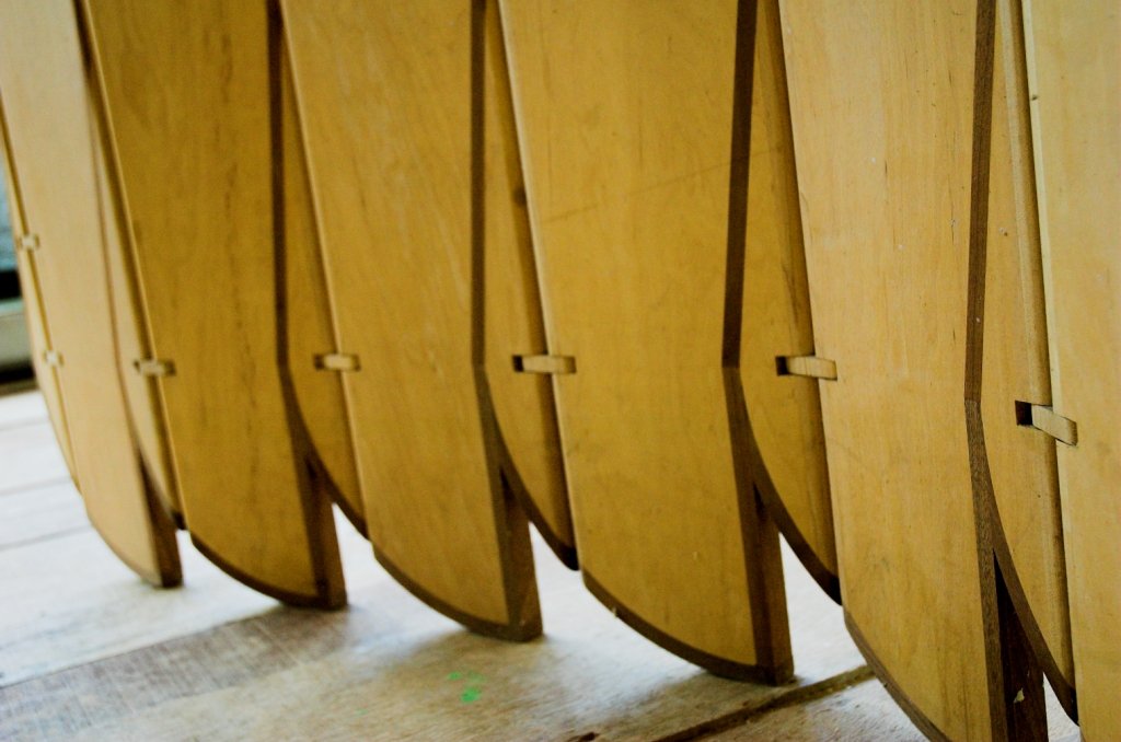 Detalhe da base da escultura móvel Onda com juntas articuladas alinhadas acima do chão.